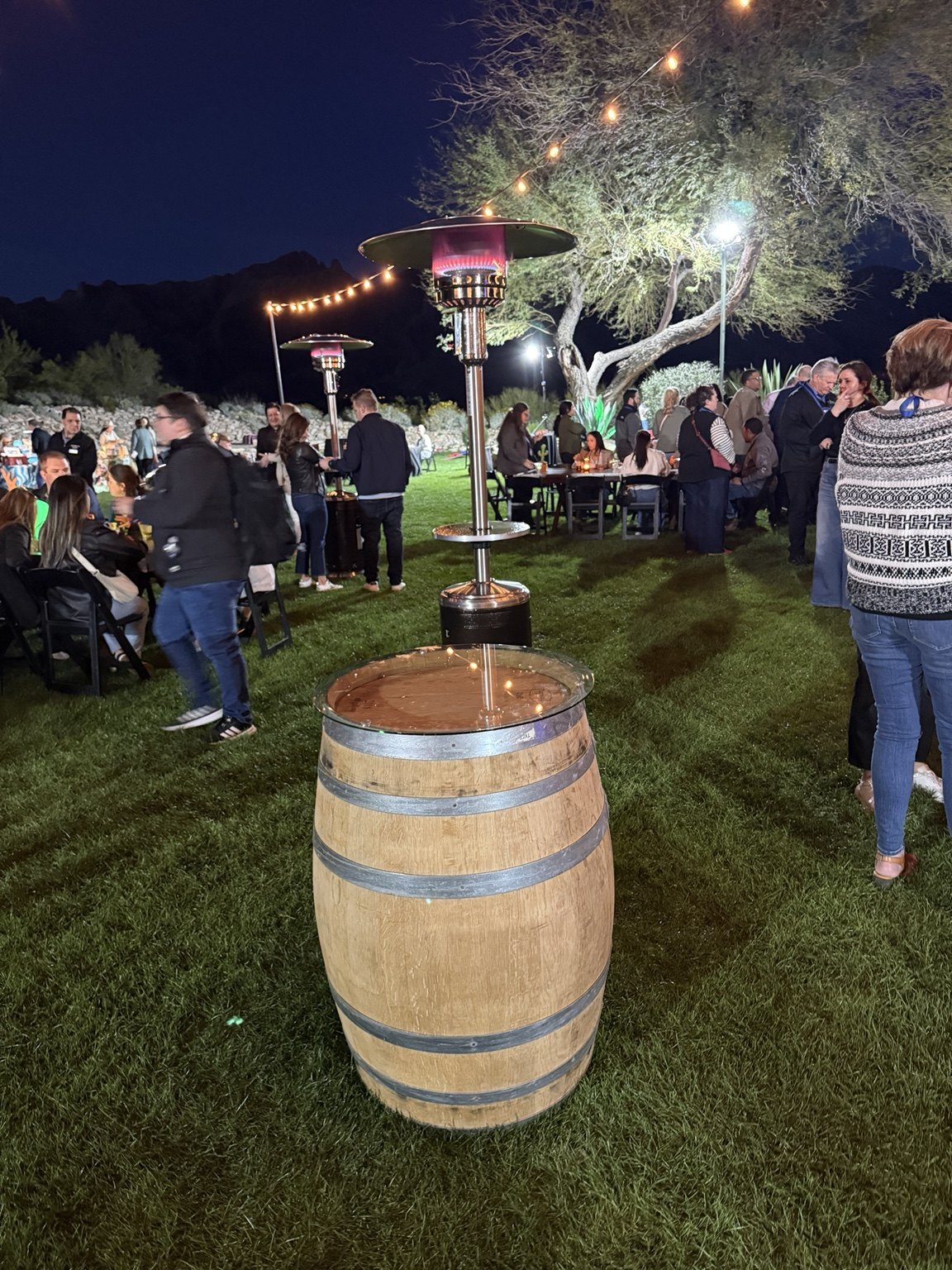 Whiskey barrel table at an evening gathering